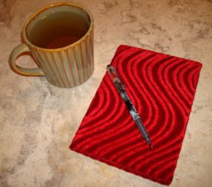 Red velvet journal, pen, and cup of tea