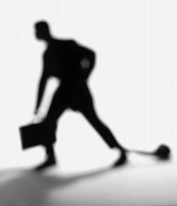 Man with brief case and ball and chain
